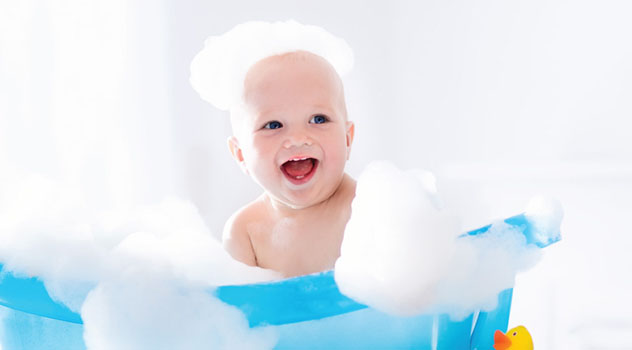 Un bambino piccolo cosparso di schiuma da bagno mentre sorride