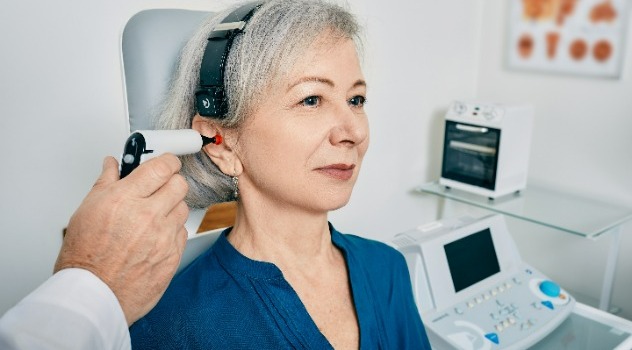 Una donna della terza età in uno studio medico mentre effettua l'impedenziometria