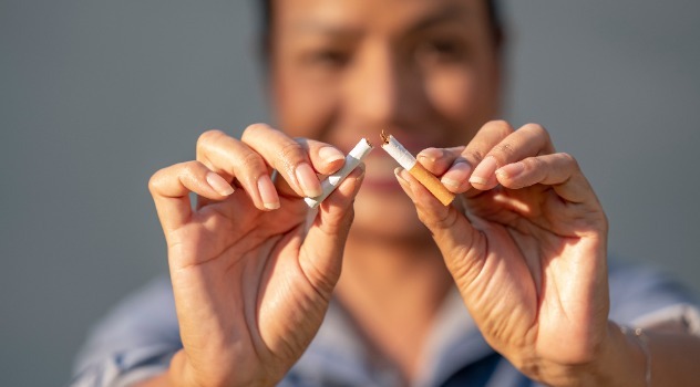 Le mani di una donna che spezzano una sigaretta