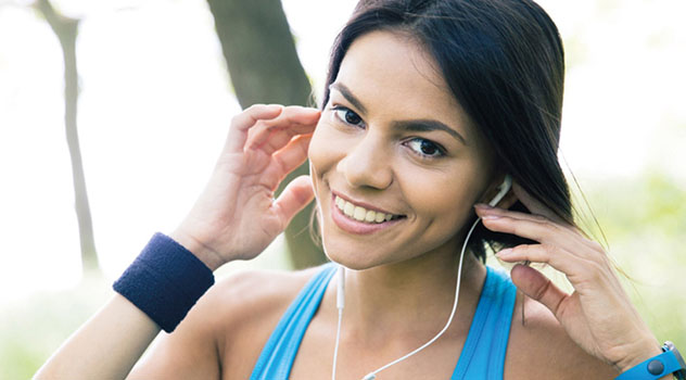 Ragazza sorridente pronta a fare jogging mentre indossa le cuffiette