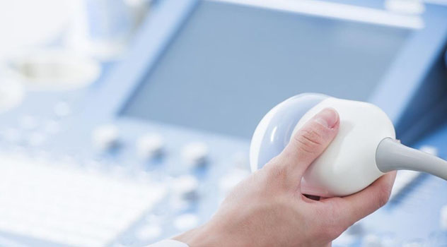 La mano di un professionista sanitario che mantiene uno strumento terapeutico per eseguire gli ultrasuoni
